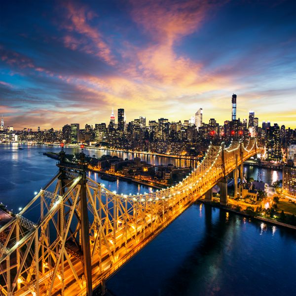 شهر نیویورک - غروب شگفت انگیز خورشید بر فراز منهتن با پل کوئینزبورو