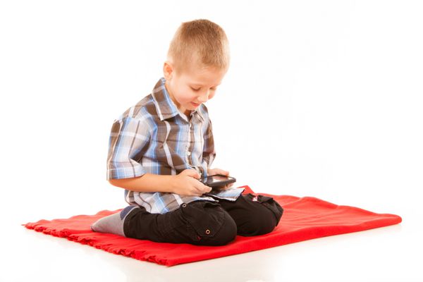 مفهوم اوقات فراغت فناوری و اینترنت - پسر کوچک با بازی های تلفن هوشمند یا خواندن پیامک