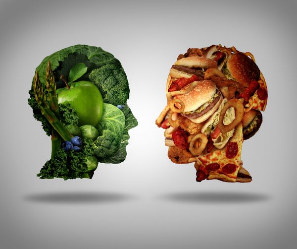انتخاب سبک زندگی و مفهوم معضل به عنوان یک فس دو انسان که یکی از سبزیجات و میوه های سبز تازه و سر دیگر با فست فودهای چرب و غذاهای سرخ شده به شکل نماد تغذیه ساخته شده است