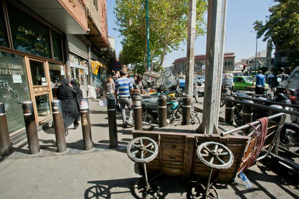 تهران ایران - 6 اکتبر مردم در پیاده رو مسدود شده از موتورسواران در شهر شلوغ در 6 اکتبر 2014 قدم می زنند تهران با جمعیت 8 3 میلیون نفر بزرگترین شهر در غرب آسیا است