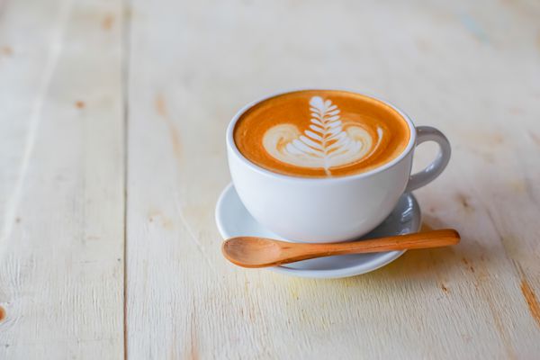 قهوه در فنجان در زمینه چوبی
