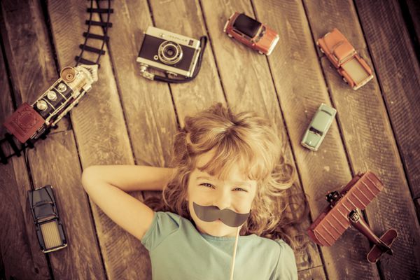 بچه هیپستر با اسباب بازی های چوبی قدیمی در خانه مفهوم قدرت دختر و فمینیسم