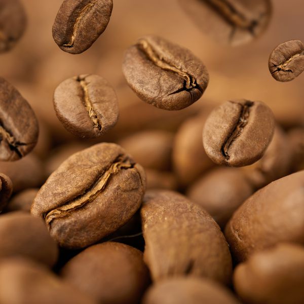 نمای نزدیک از دانه های قهوه با تمرکز روی یکی