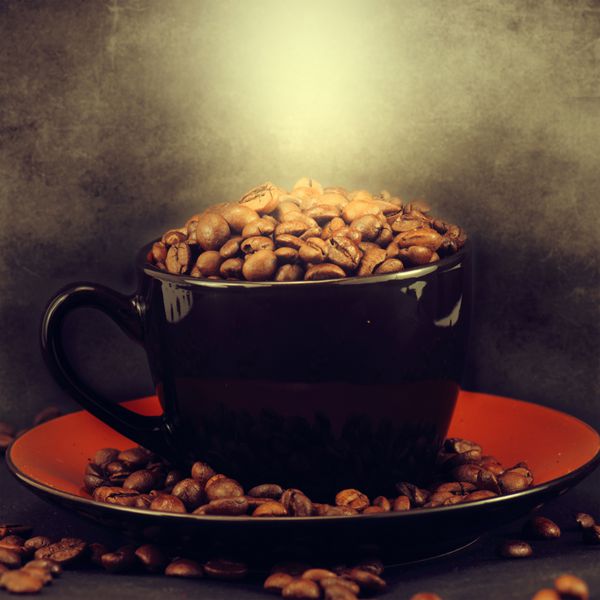 فنجان پر از دانه های قهوه