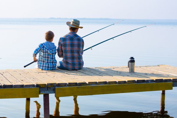 پسر و پدرش در حال ماهیگیری با هم از اسکله