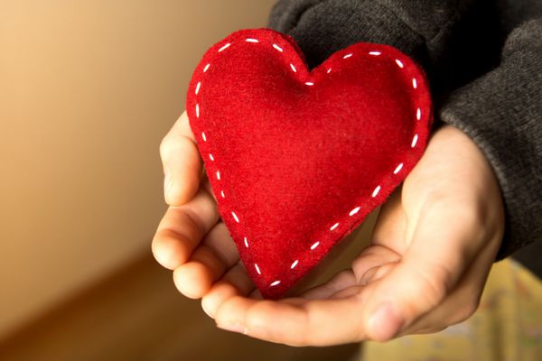 قلب قرمز در دستان کودک هدیه دست ساز نزدیک افقی