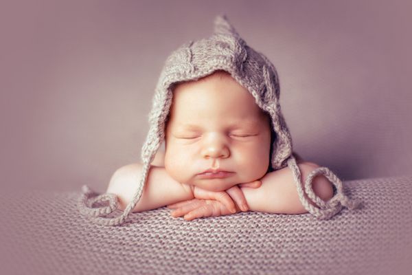 نوزاد در کلاه بر روی پتو دسته تا شده