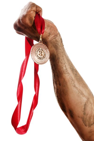 مدال طلا در دست جدا شده روی سفید