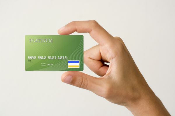 نمای نزدیک کارت اعتباری سبز که با دست نگه داشته شده است