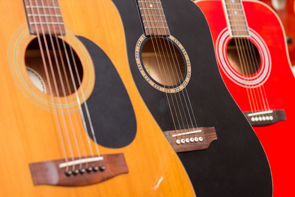 نمای نزدیک از گیتارها در یک فروشگاه موسیقی تمرکز انتخابی