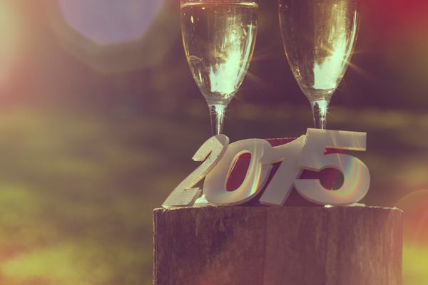 لیوان شامپاین با اعداد مقوایی 2015 و افکت شعله ور شدن لنز