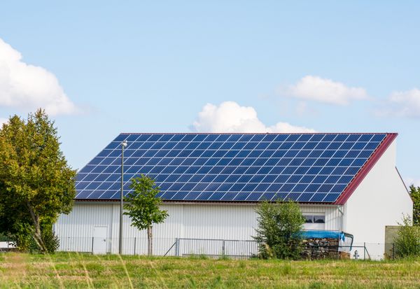 انرژی سبز با کلکتورهای خورشیدی در پشت بام یک ساختمان کشاورزی