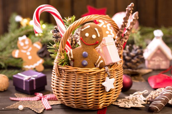 سبد غذاهای مختلف کریسمس مرد شیرینی زنجبیلی هدایا و تزئینات روی میز
