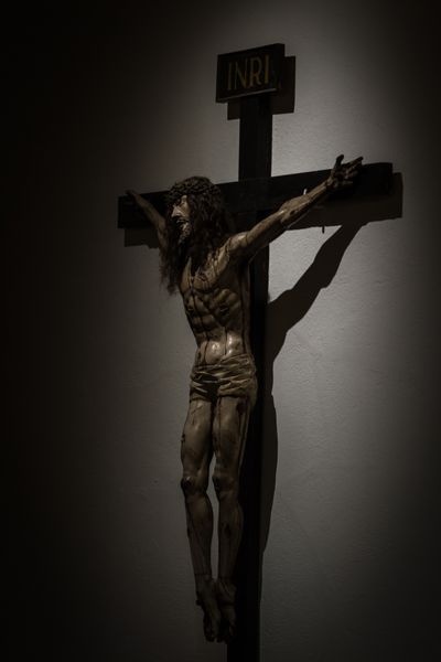 نزدیک با نور دراماتیک مجسمه عیسی مسیح روی صلیب