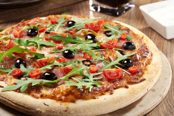 پیتزا پپرونی در بشقاب با زیتون سیاه و پنیر موزارلا
