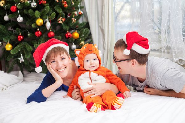 خانواده جوان با نوزاد پسری که لباس روباه پوشیده است