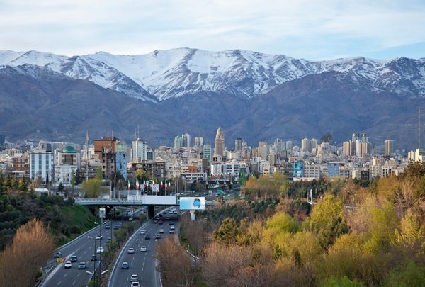 خط افق تهران و سرسبزی در مقابل کوه های البرز پوشیده از برف از بالای پل طبیعت