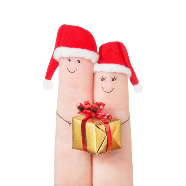 انگشتان در کلاه بابا نوئل با جعبه هدیه ایزوله شده در پس زمینه سفید مفهوم جشن برای کریسمس یا روز سال نو