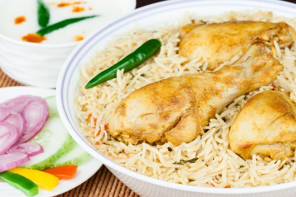 مرغ بریانی نزدیک - نمای ماکرو بریانی مرغ هندی خوشمزه با تزیین با رایتا و سالاد رنگارنگ سرو می شود ارائه سنتی