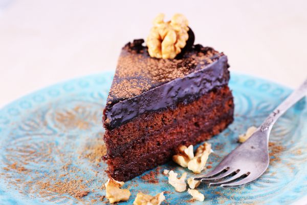 کیک شکلاتی خوشمزه در بشقاب در پس زمینه روشن