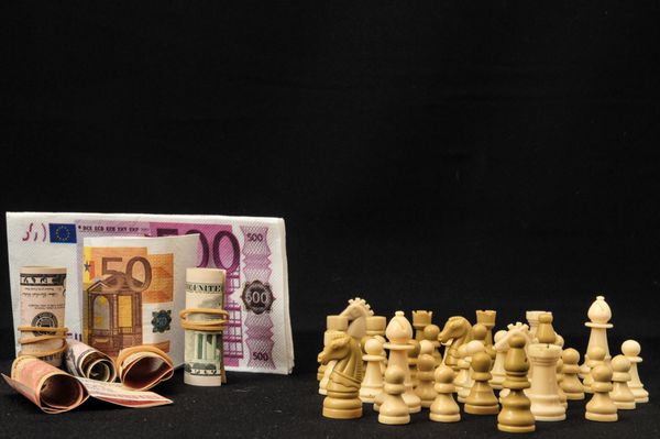 مفهوم استراتژی پول شطرنج سفید و ارز در پس زمینه سیاه
