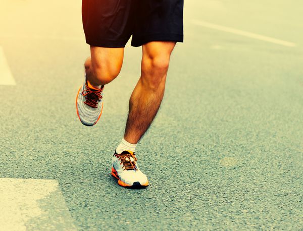 دویدن پاهای ورزشکار ماراتن ناشناس در جاده شهر
