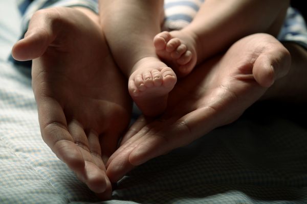 عکس دقیق از پای نوزاد در دستان مادر