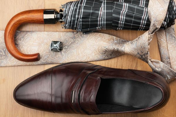 کفش های مردانه کلاسیک کراوات چتر دکمه سرآستین روی کف چوبی می توانند به عنوان پس زمینه استفاده شوند