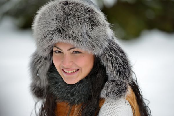 پرتره زن زیبا و خندان با پارچه سر خز مجلل در فضای باز در زمستان