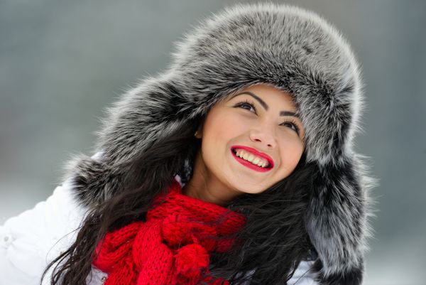 پرتره زن زیبا و خندان با پارچه سر خز مجلل در فضای باز در زمستان