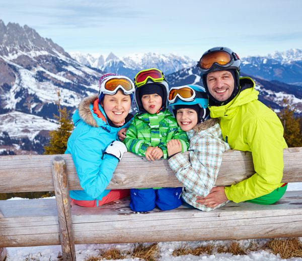اسکی بازان آفتاب و سرگرمی - خانواده با دو کودک که از تعطیلات زمستانی لذت می برند