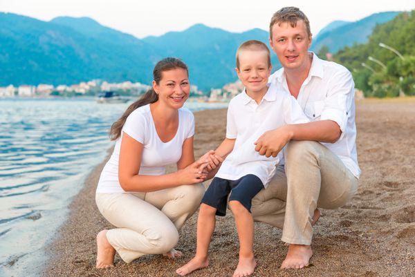 خانواده شاد با فرزند در تعطیلات در دریا