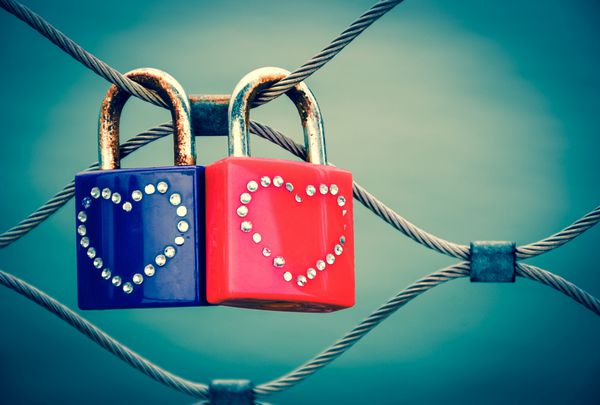 دو قفل عشق گرانی با تزئینات قلبی متصل به پل در پاریس پس زمینه روز تندی po