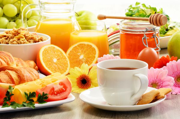 صبحانه شامل میوه ها آب پرتقال قهوه عسل نان و تخم مرغ است رژیم غذایی متعادل