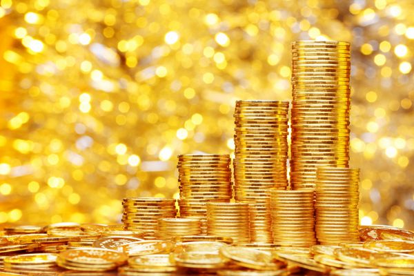 سکه های طلایی جدید درخشان روی پس زمینه بوکه درخشان با نور روشن ثروت مالی کسب و کار و مفهوم موفقیت