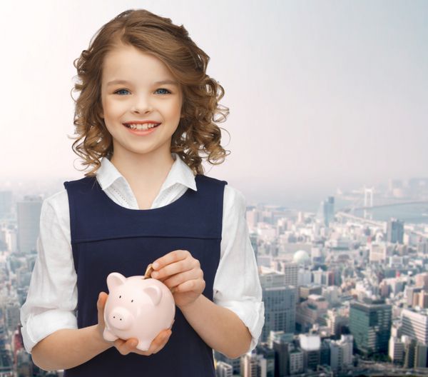مردم پول پس‌انداز سرمایه‌گذاری و مفهوم کودکان - دختر خندان در حال گذاشتن سکه در قلک در پس‌زمینه شهر
