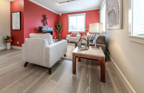 سوئیت نشیمن لوکس مدرن با دیوارهای رنگ قرمز اتاق با مبل و صندلی و به زیبایی با میز قهوه گلدان تزئین شده است طراحی داخلی یک خانه کاملا جدید
