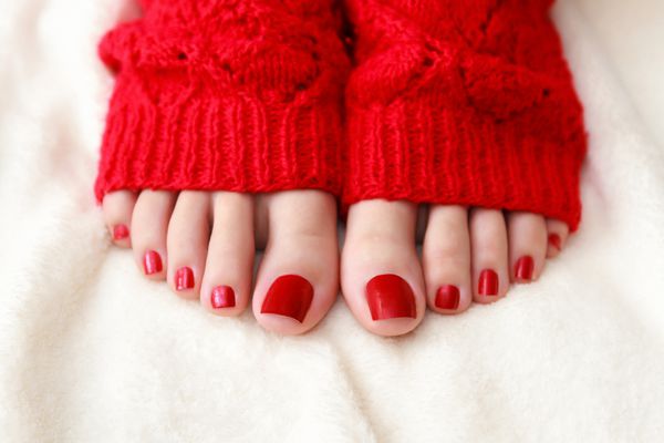 پاهای زن با پدیکور در جوراب قرمز
