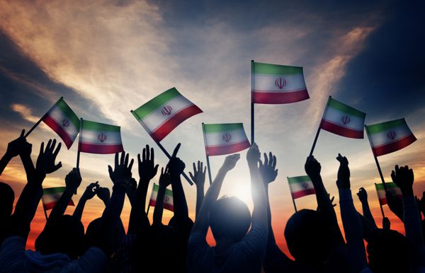 سیلوئت افرادی که پرچم ایران را به اهتزاز در می آورند