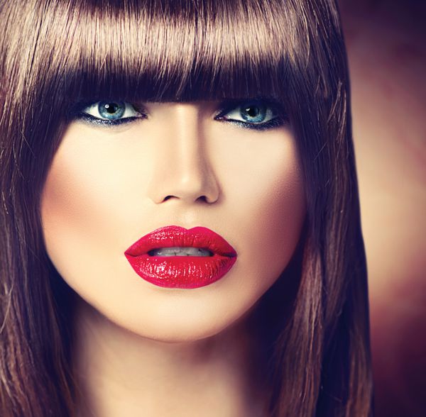 زن زیبا با مدل موی شیک و آرایش حرفه ای لب های قرمز موهای قهوه ای صاف