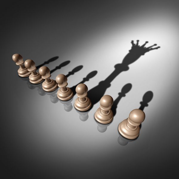 مفهوم جستجوی رهبری و استخدام کسب و کار به عنوان گروهی از مهره های شطرنج پیاده و یک فرد برجسته با تاج پادشاهی به عنوان استعاره ای برای فرد منتخب