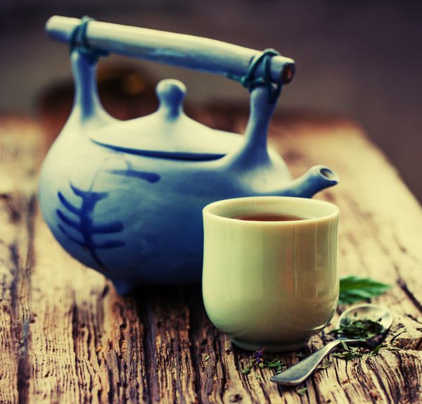 ست چای چینی چای گیاهی به سبک چینی روی میز چوبی با مواد خام