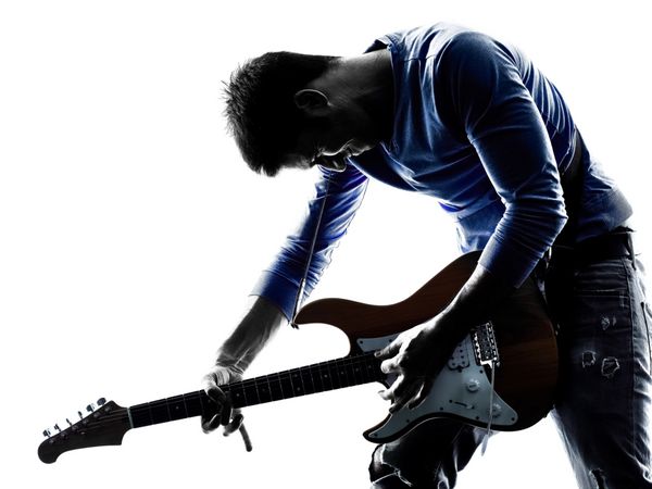 یک نوازنده گیتاریست الکتریک مرد قفقازی در شبح استودیو جدا شده در پس زمینه سفید