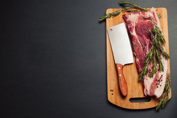 گوشت خوک تازه گوشت خام روی تخته برش ادویه رزماری و گوشت تبر و خوک گوشتی قطعه چاق