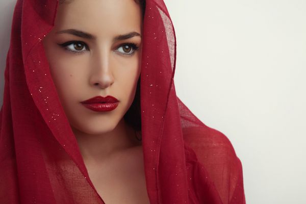 پرتره زن زیبا با لب های قرمز و حجاب قرمز بالای سرش استودیو s
