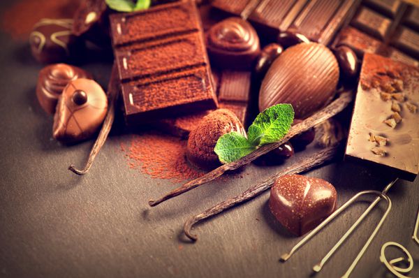 پس زمینه شکلات شکلات مجموعه ای از شکلات های خوب در شکلات تیره و شیری با وانیل و نعنا شیرینی شکلاتی پرالین