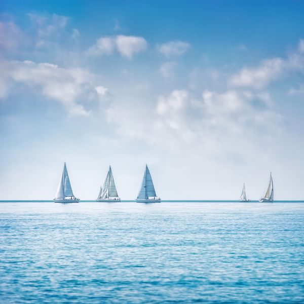 قایق بادبانی قایق بادبانی یا گروه قایق بادبانی رگاتا روی آب دریا یا اقیانوس منظره وسیع دید پانورامایی