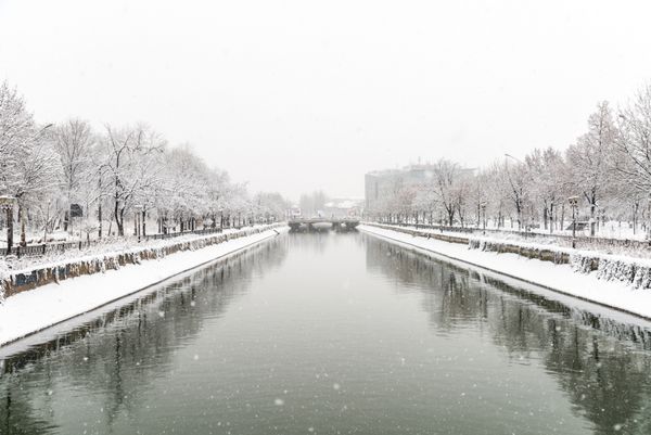 بخارست رومانی - 30 دسامبر 2014 رودخانه دامبوویتا در هنگام بارش برف سنگین در زمستان از بخارست می گذرد و برای قرن ها منبع اصلی آب آشامیدنی شهر بخارست بوده است