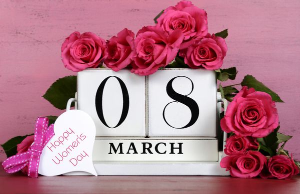 تاریخ تقویم روز جهانی زن بلوک چوبی قدیمی برای 8 مارس با گل رز در زمینه چوبی صورتی و قرمز