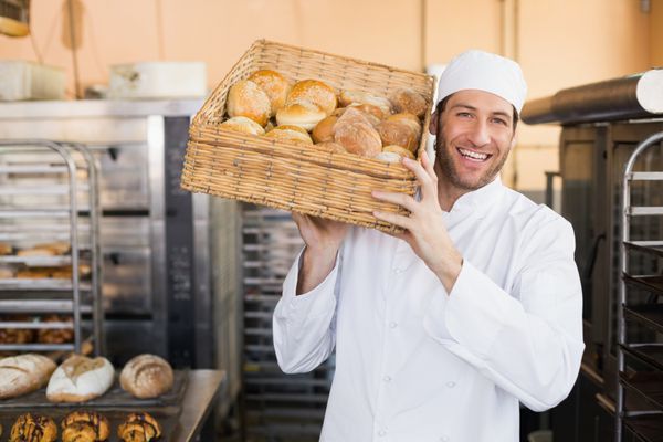 نانوایی که سبد نان در آشپزخانه نانوایی در دست دارد